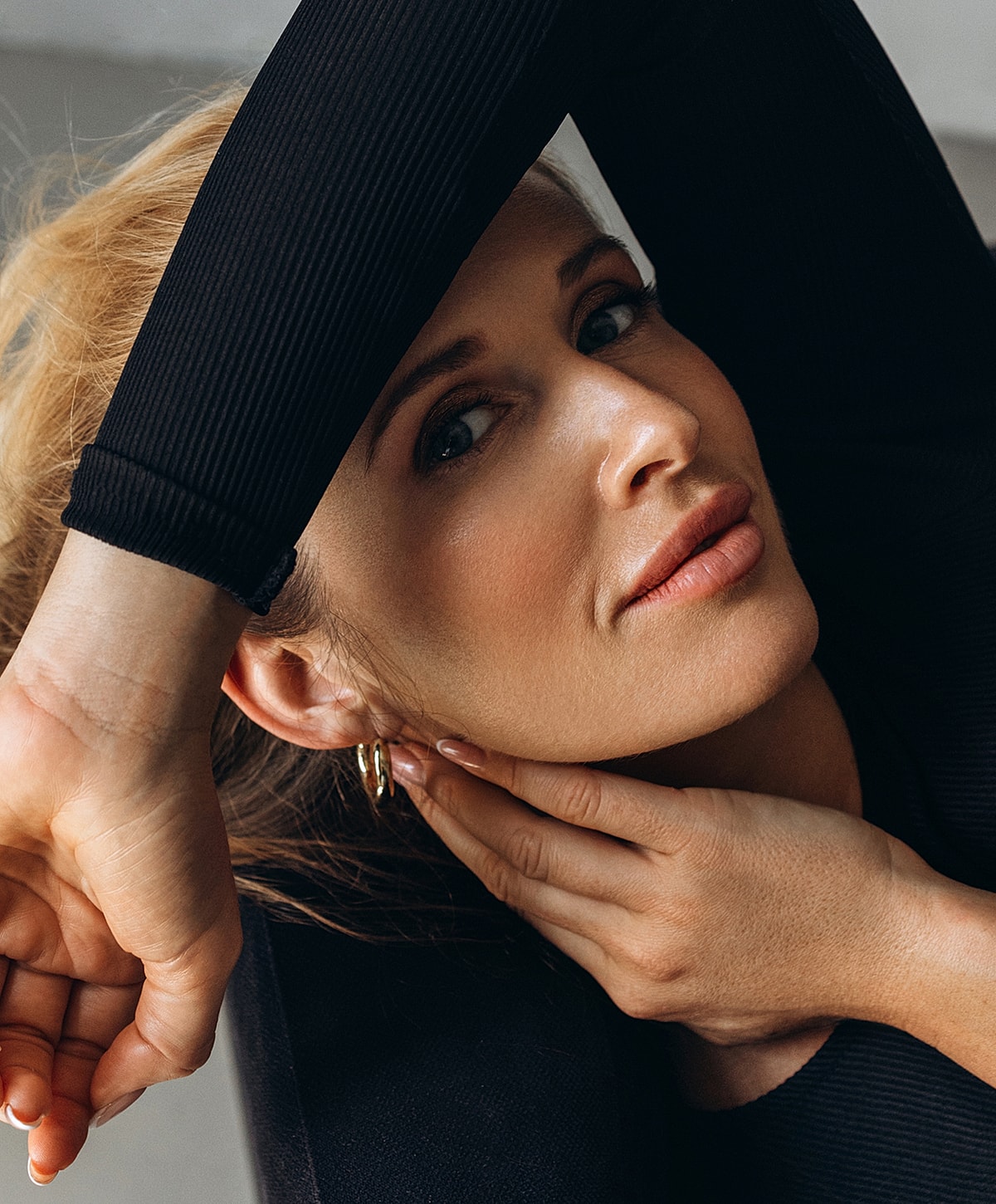 ipl photofacial patient model resting her head, wearing black clothing.