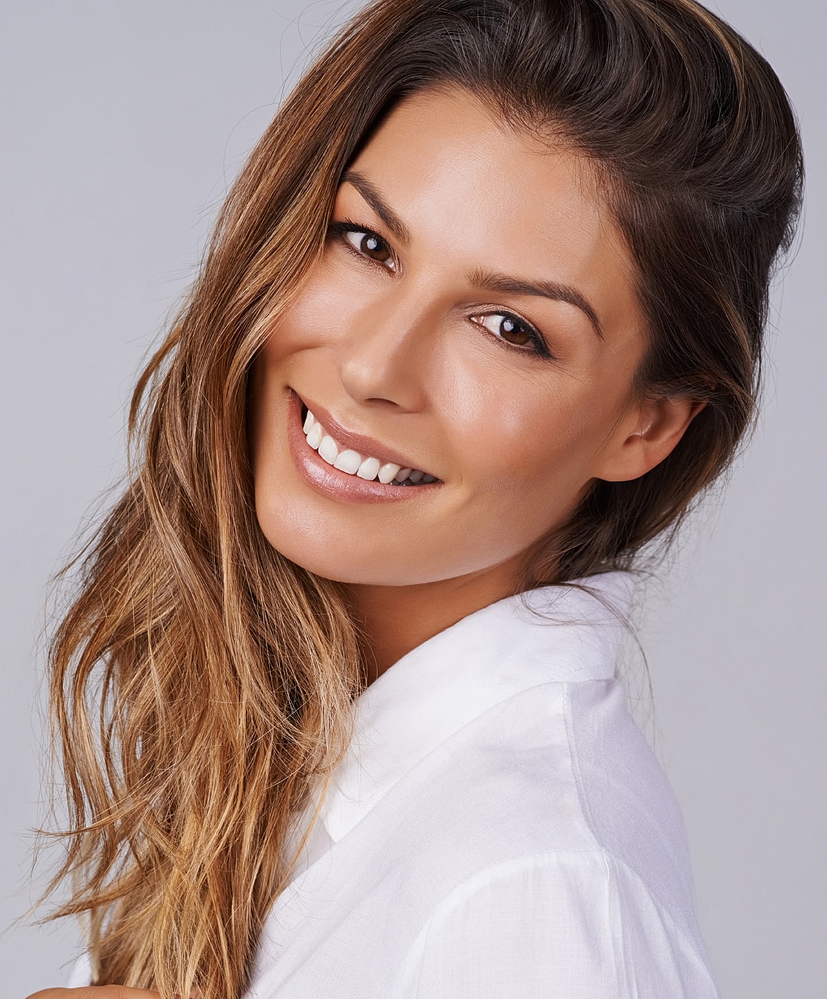 Smiling woman with long hair in white shirt.