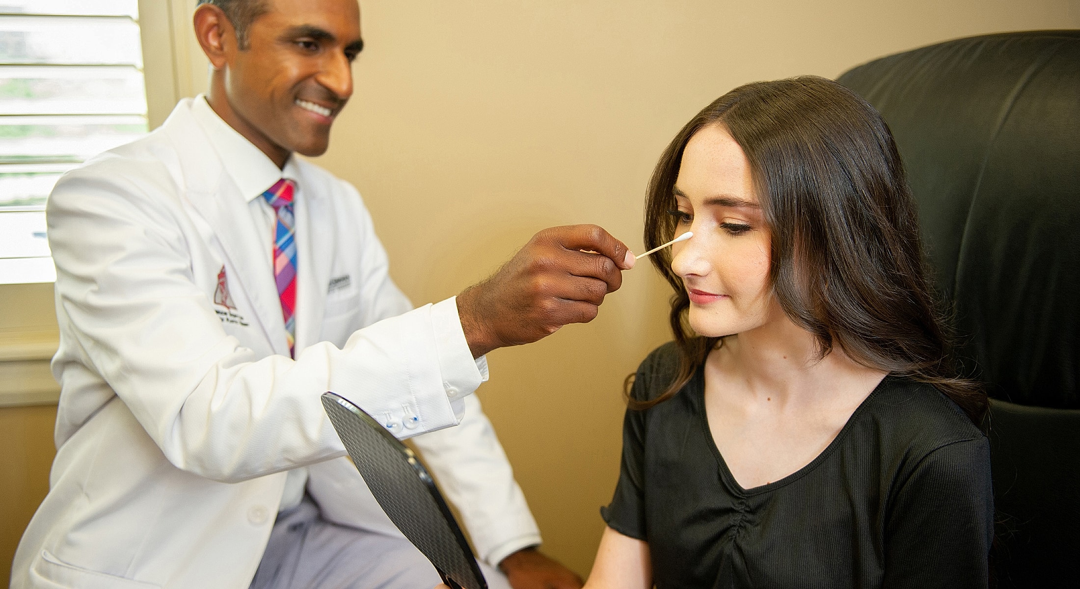 Dr. Narasimhan consulting with a rhinoplasty patient model