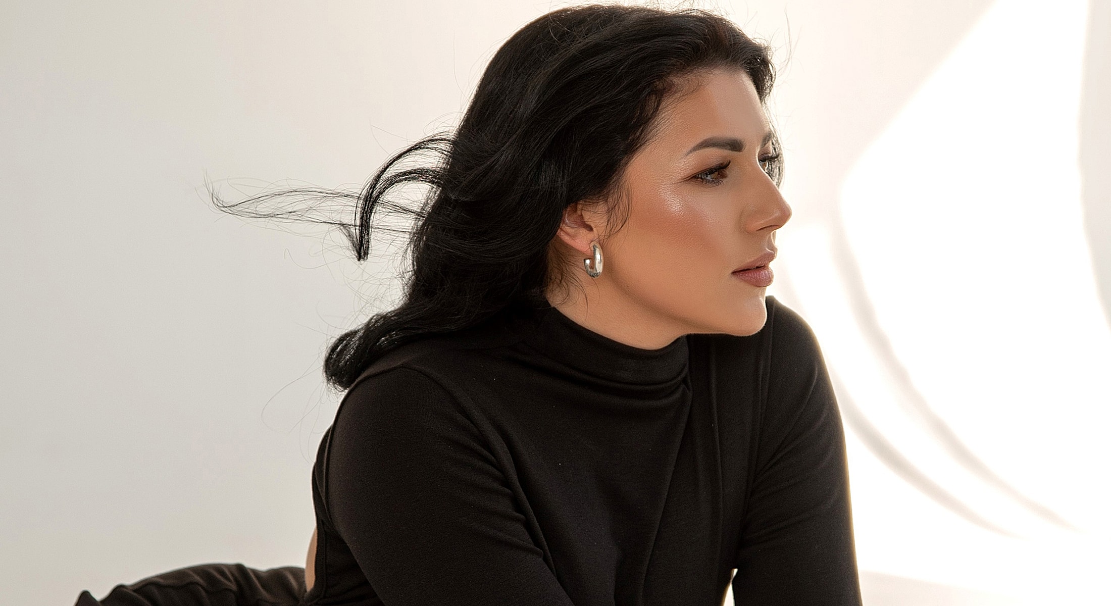 Woman with curly hair and natural makeup.