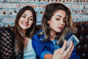 two young, attractive women looking at smartphone